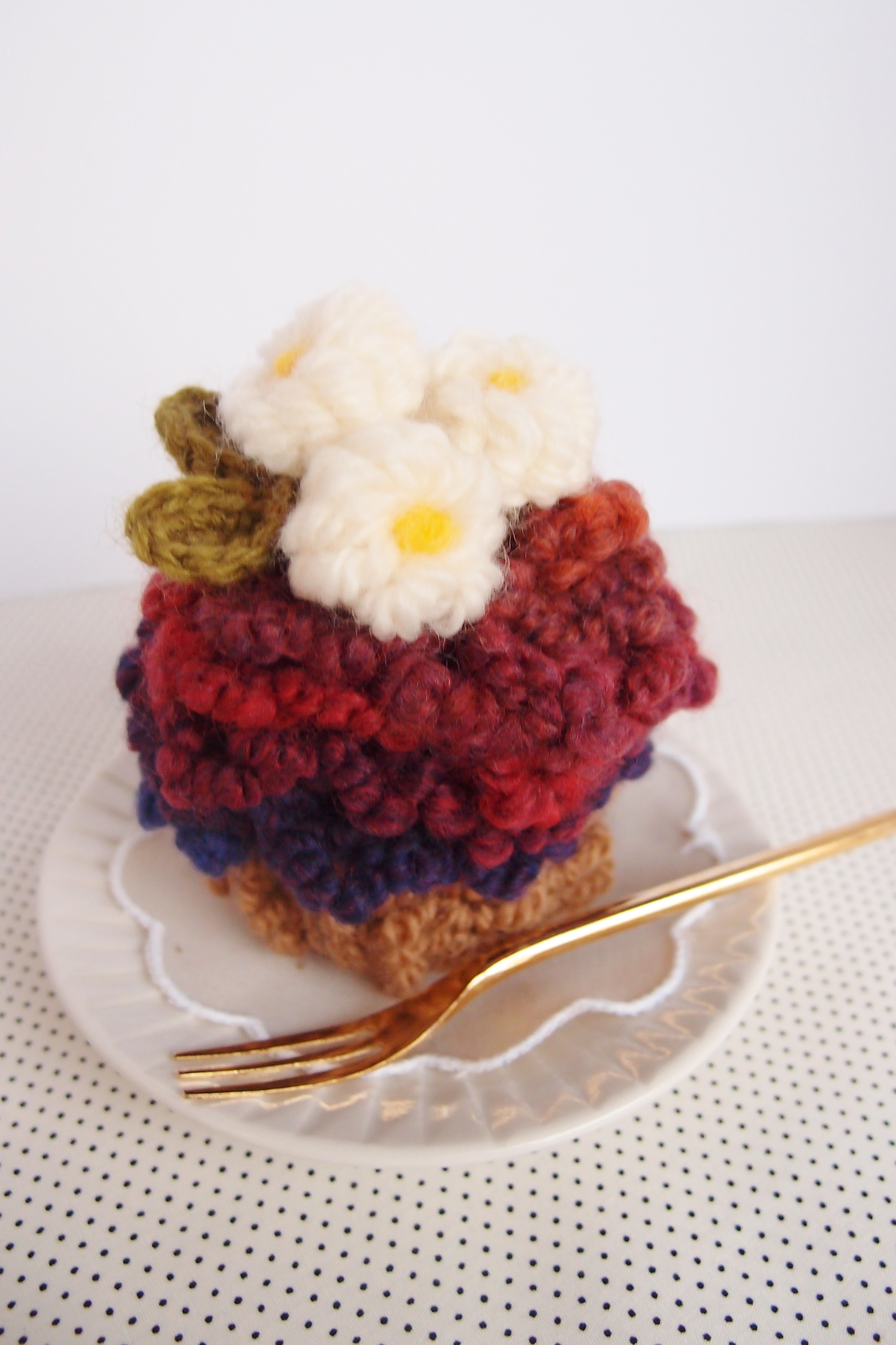 かぎ針で編んだ、毛糸のカップケーキ